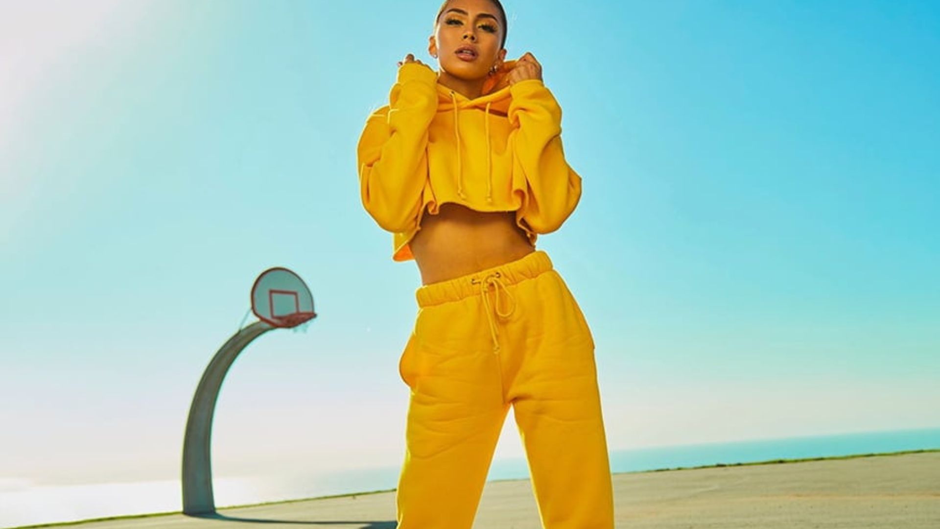 a young lady wearing a yellow tracksuit posing for a photo